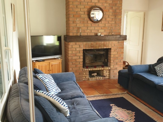 Living Room with wood burning stove and doors leading onto both front and rear patio areas and garden